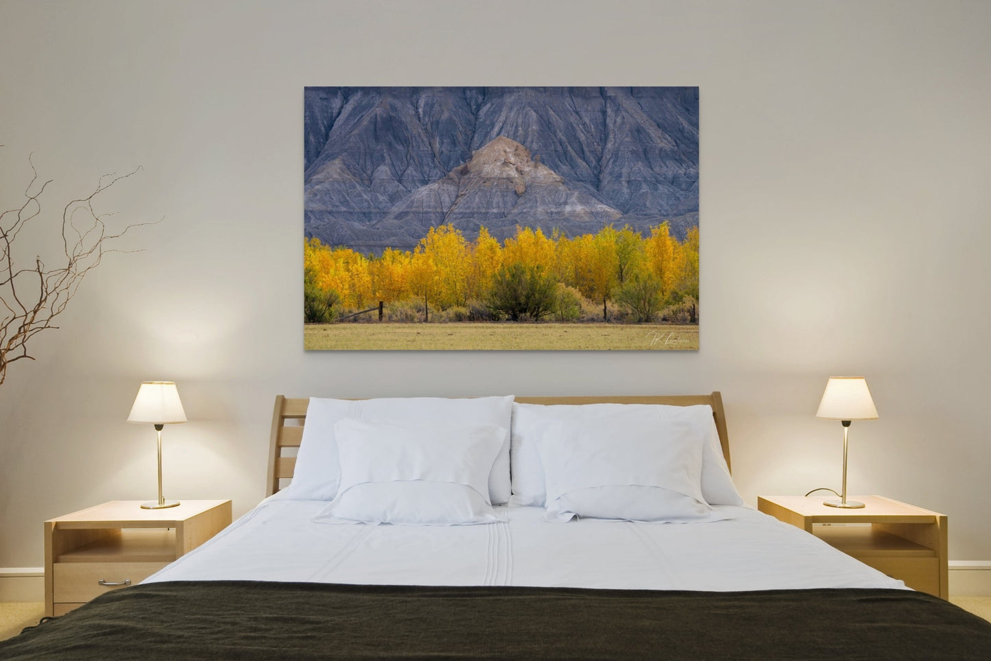A wall art mockup featuring the photograph titled, "A Poplar Place" shot by landscape photographer J K Lovelace, as a metal print with inset frame on wall above simple bed.