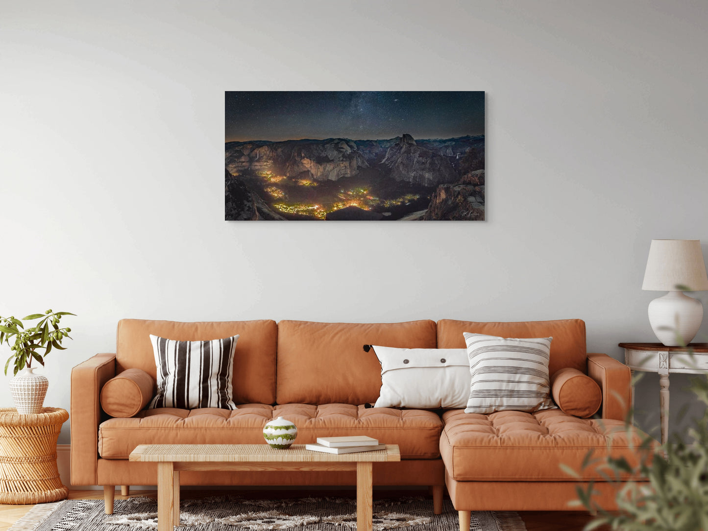 A wall art mockup featuring the photograph titled "Artificial Darkness" by landscape photographer J K Lovelace as a 60 inch wide metal print with inset frame on display in a boho chic living room.