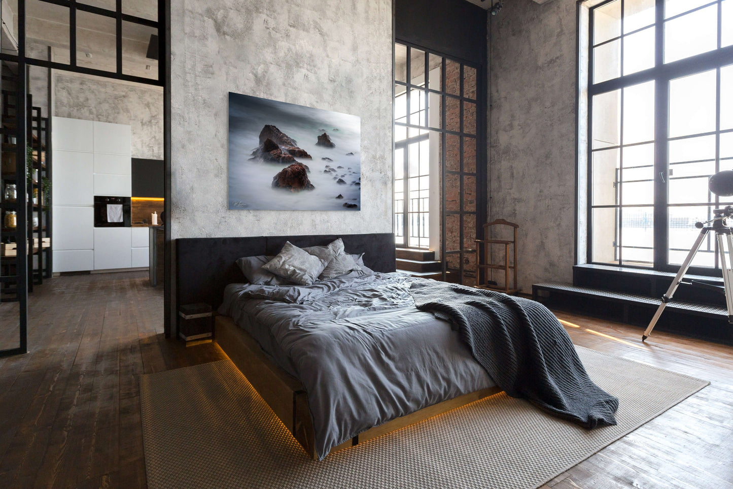 A wall art mockup featuring the photograph titled "Beyond Here Be Dragons" by landscape photographer J K Lovelace as a 60 inch wide metal print with inset frame on display in an industrial loft apartment.