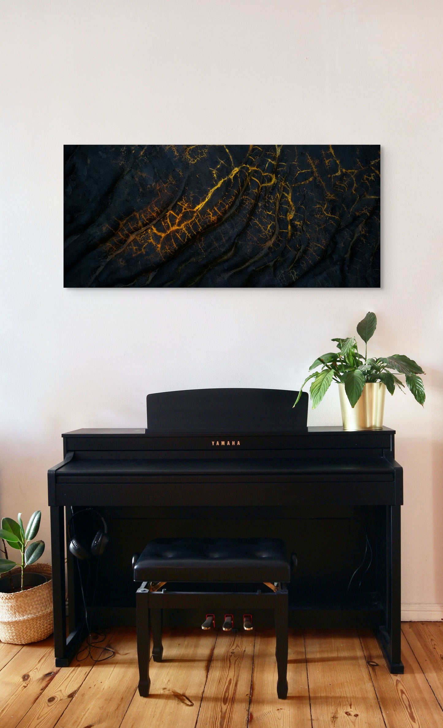 A wall art mockup featuring the photograph titled "Golden Veins" by landscape photographer Ben Coffman as a 48 inch wide metal print with inset frame on display above piano in a modern apartment.