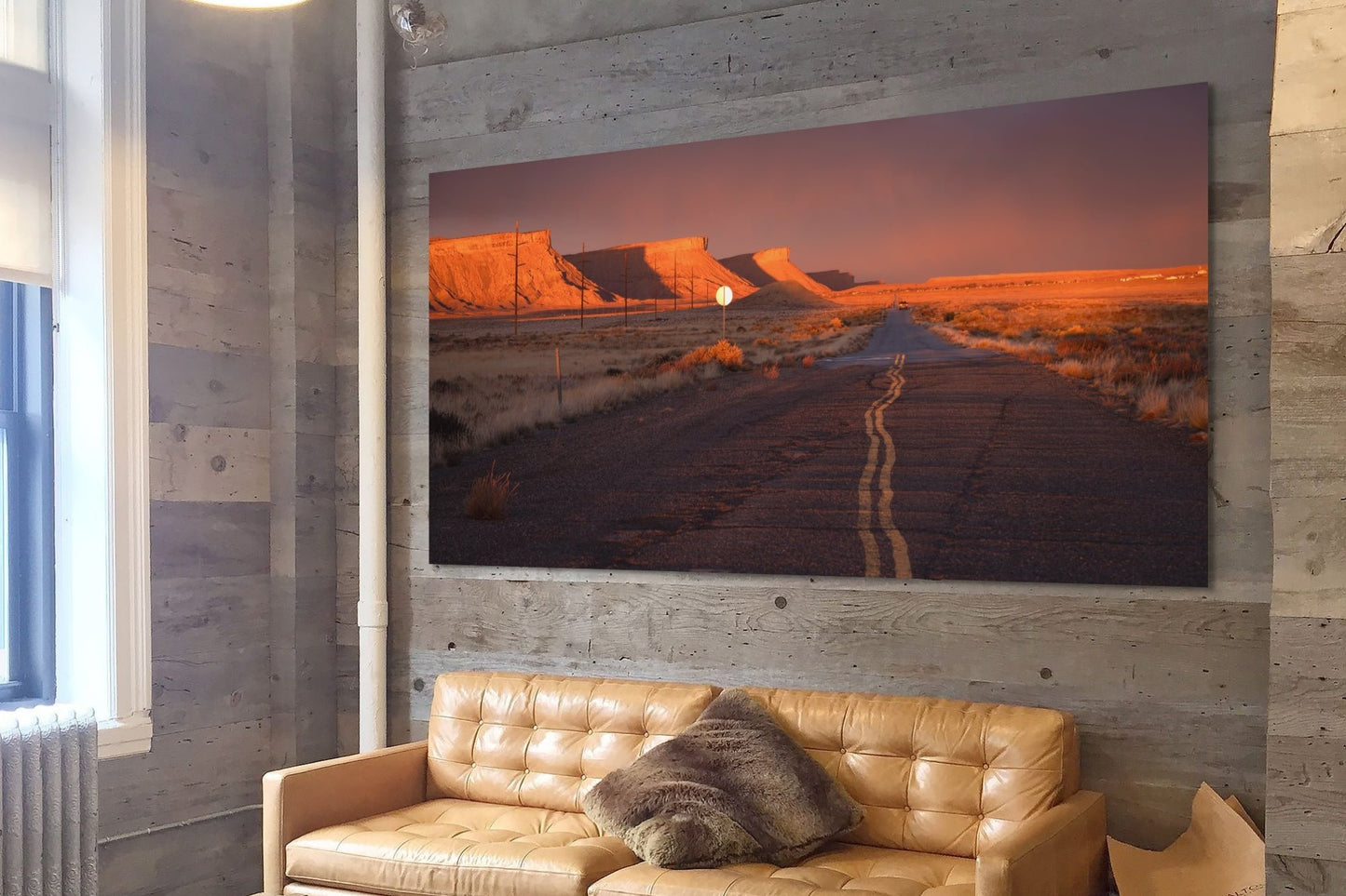 A wall art mockup featuring the photograph titled, "Heading Home" by landscape photographer J K Lovelace, as a 96 inch wide metal print with inset frame on display in a rustic space.
