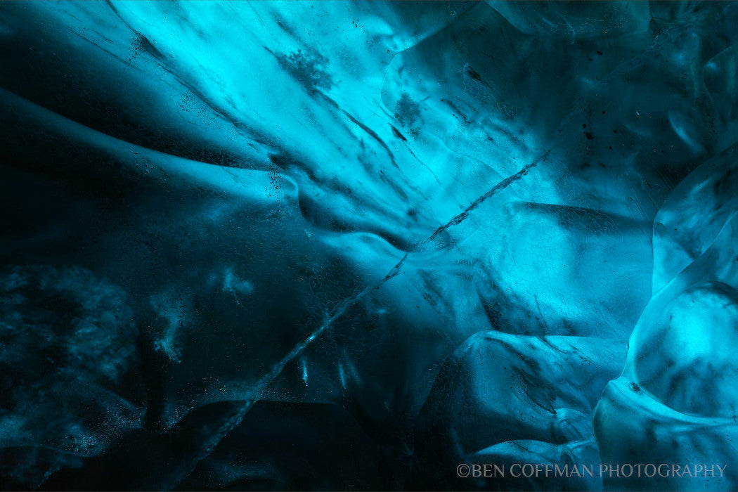 A jpg of the abstract photograph titled "Ice Nebulae II" shot by landscape photographer Ben Coffman, featuring black and blue translucent ice.