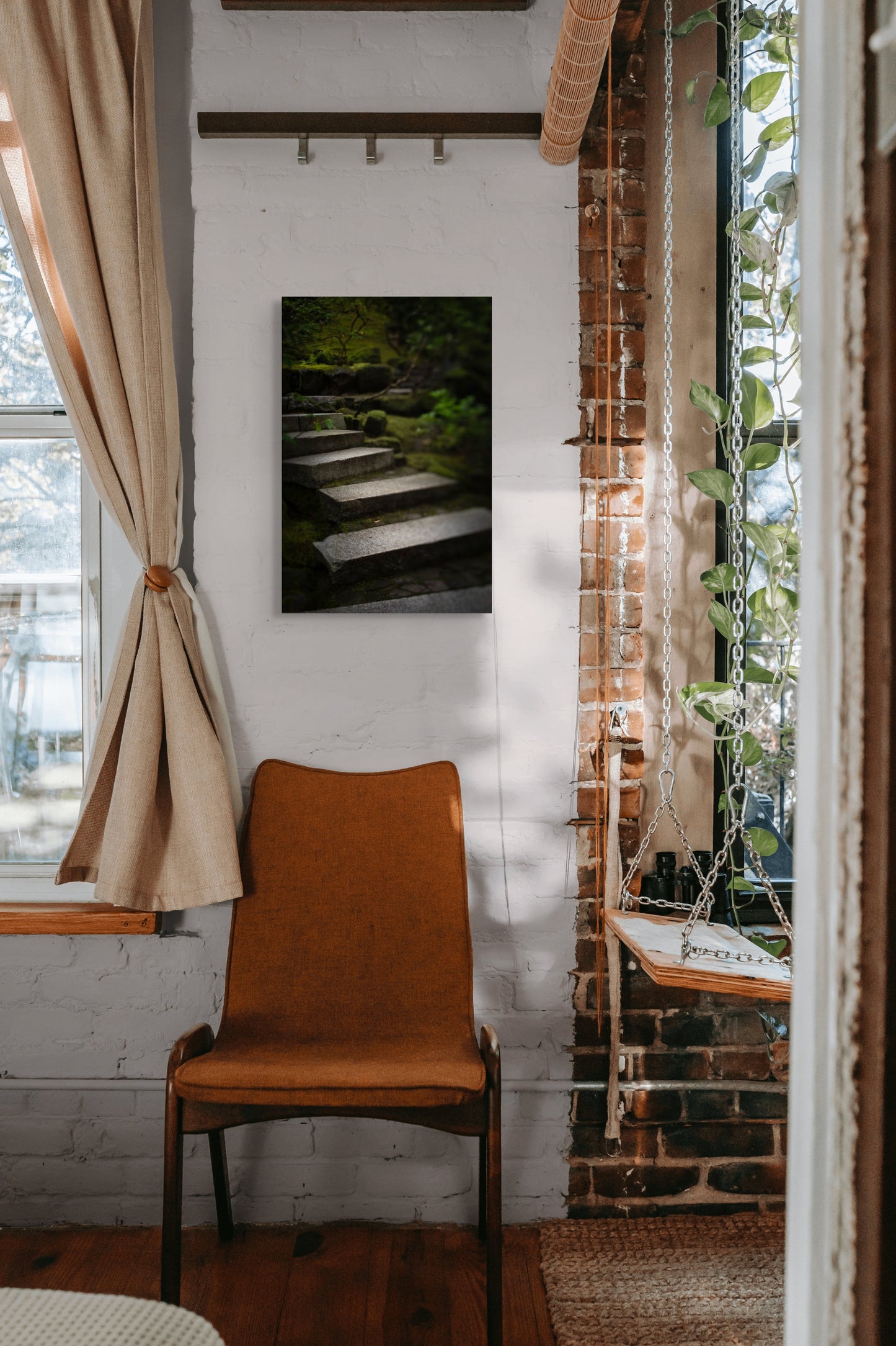 A wall art mockup featuring the photograph titled "Liminal Spaces in the Portland Japanese Garden 10" by landscape photographer Ben Coffman as a 17 inch wide metal print with inset frame on display in a boho chic apartment.