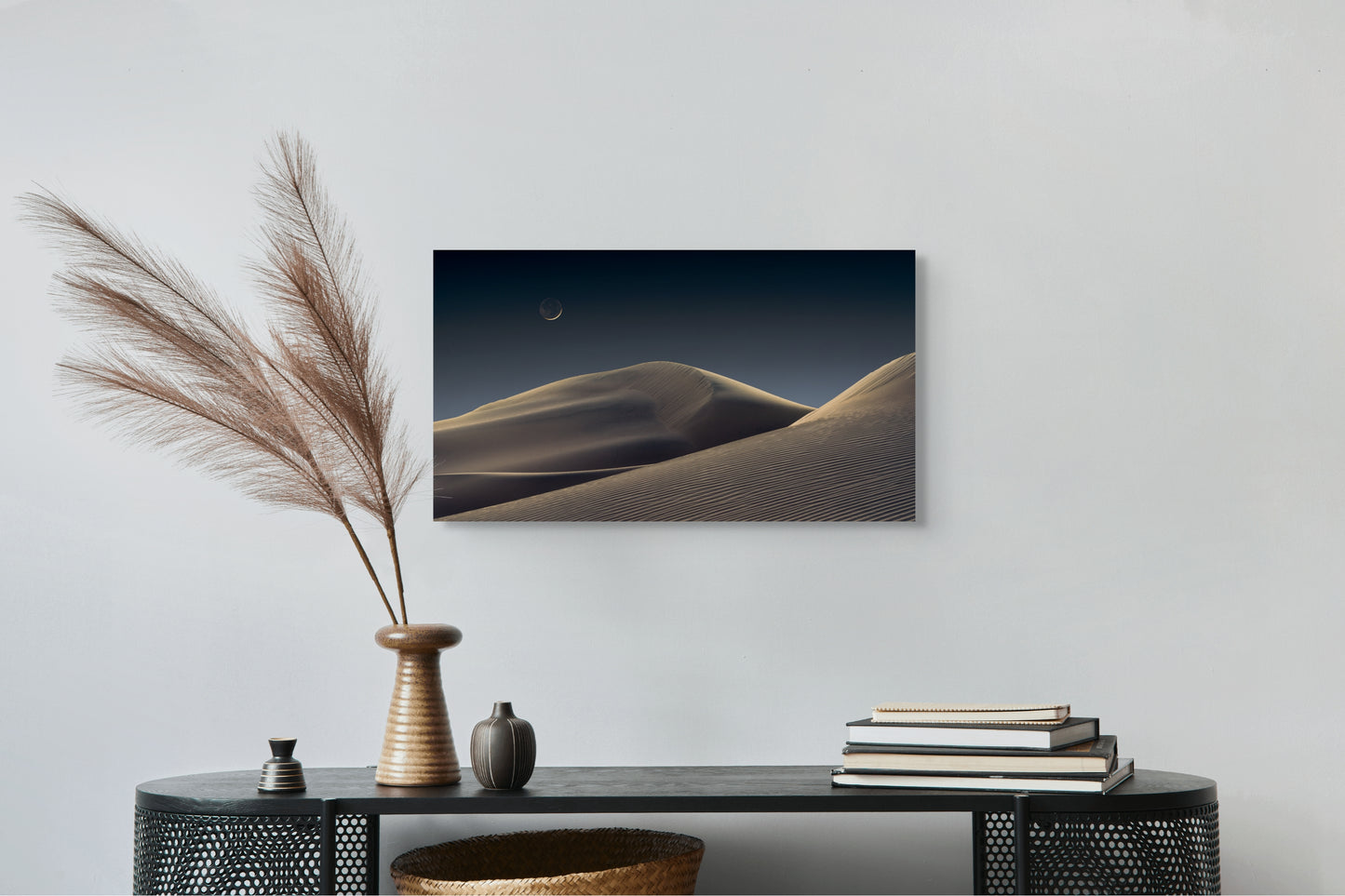 A wall art mockup featuring the photograph titled "Luna Dunes" by landscape photographer J K Lovelace as a 30 inch wide metal print with inset frame on display above black console table.
