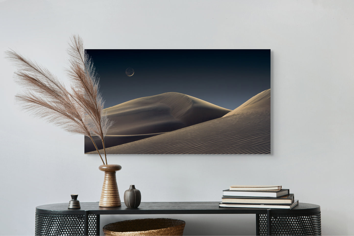 A wall art mockup featuring the photograph titled "Luna Dunes" by landscape photographer J K Lovelace as a 44 inch wide metal print with inset frame on display above black console table.