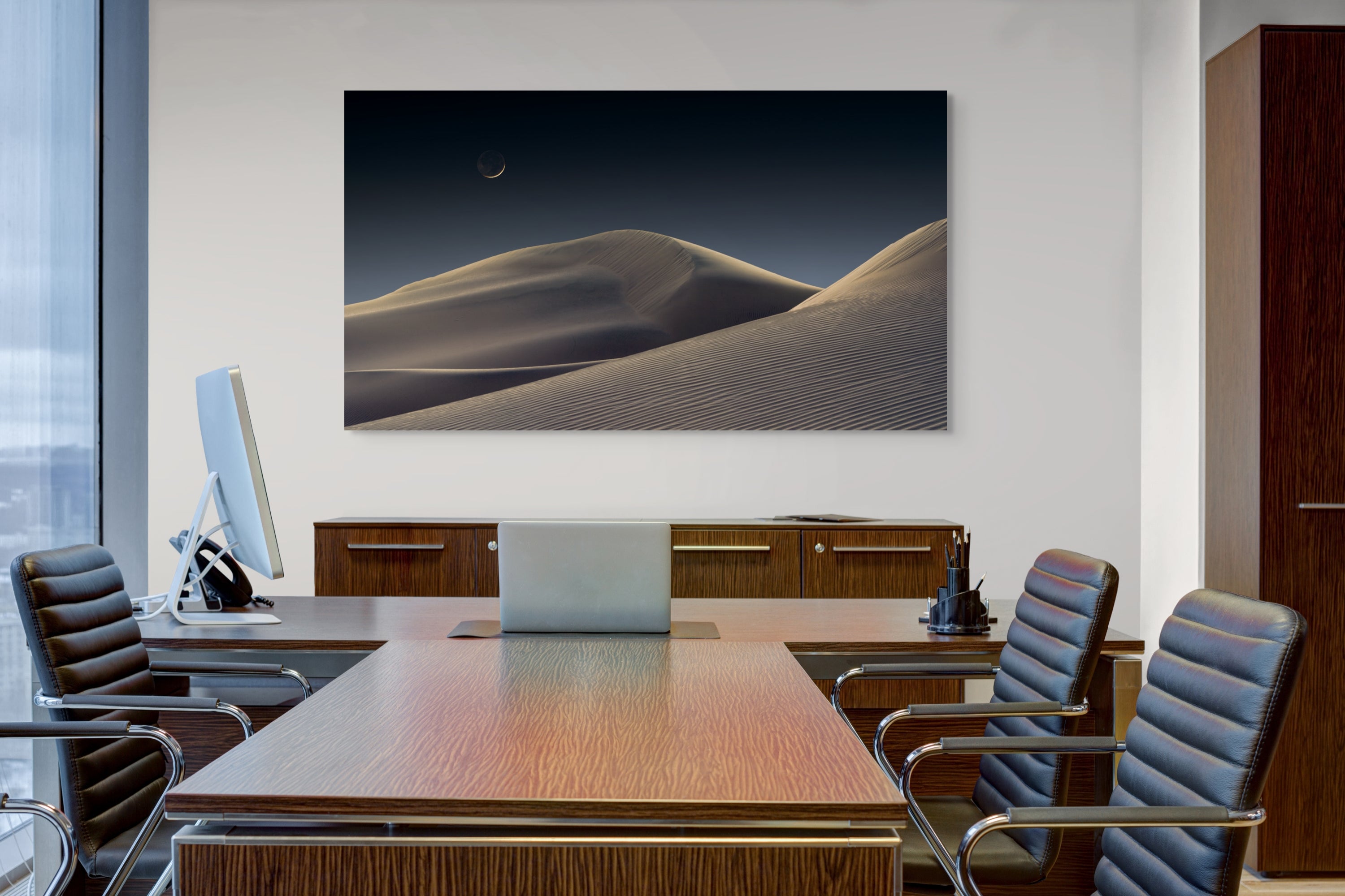 A wall art mockup featuring the photograph titled "Luna Dunes" by landscape photographer J K Lovelace as a 60 inch wide metal print with inset frame on display in corporate boardroom.