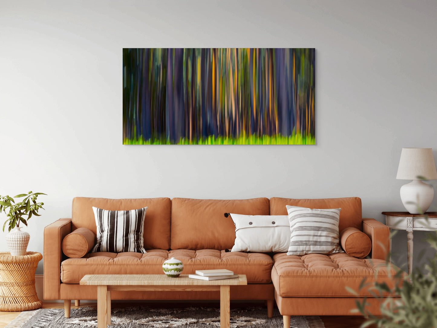 A wall art mockup featuring the photograph titled "Rainbow Eucalyptus, Big Island" by landscape photographer Ben Coffman as a 72 inch wide metal print with inset frame on display in a boho chic living room.