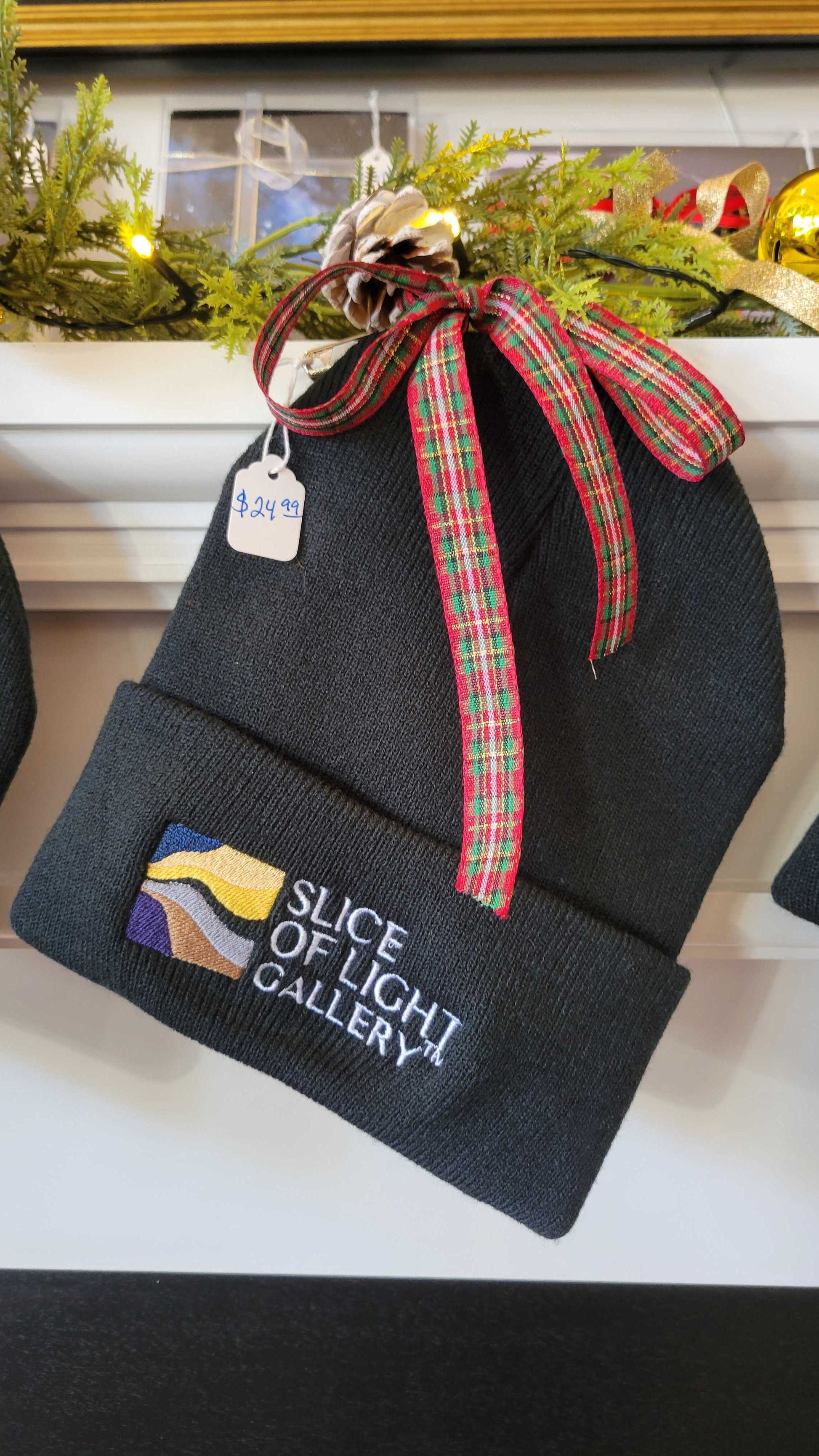 A photograph of a slice of light gallery beanie for sale on a fireplace mantel with xmas ribbon