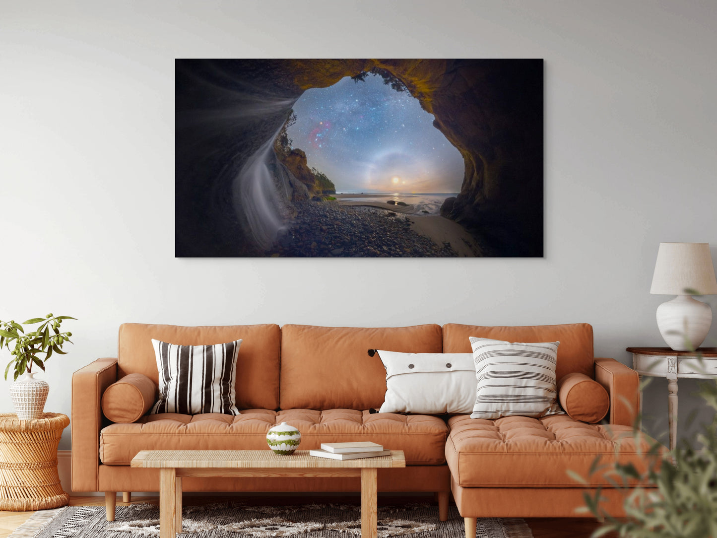 A wall art mockup featuring the photograph titled "Starfalls II" by landscape photographer Ben Coffman as a 84 inch wide metal print with inset frame on display in a boho chic living room.