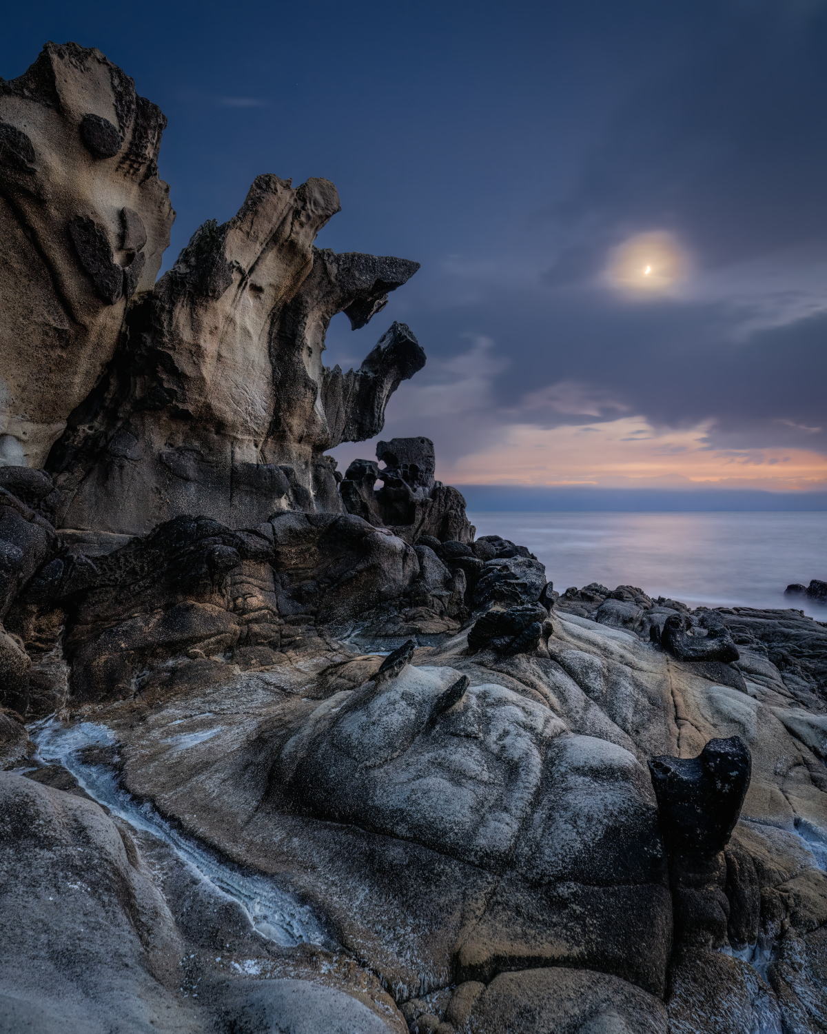 A png of the seascape photograph titled "The Ancient Mariner" shot by landscape photographer J K Lovelace featuring interesting rock formations, the sea, and a cloudy moon.