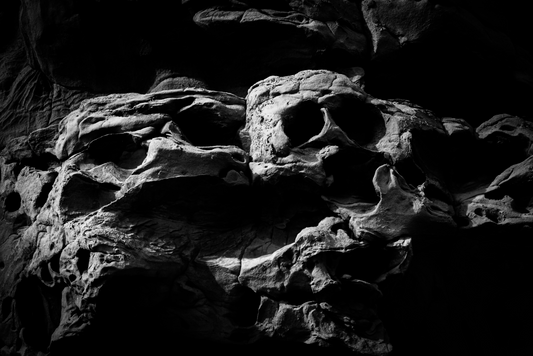 A png of the black and white photograph titled "The Skull of Ozymandias" shot by landscape photographer J K Lovelace featuring pareidolic rock formations.
