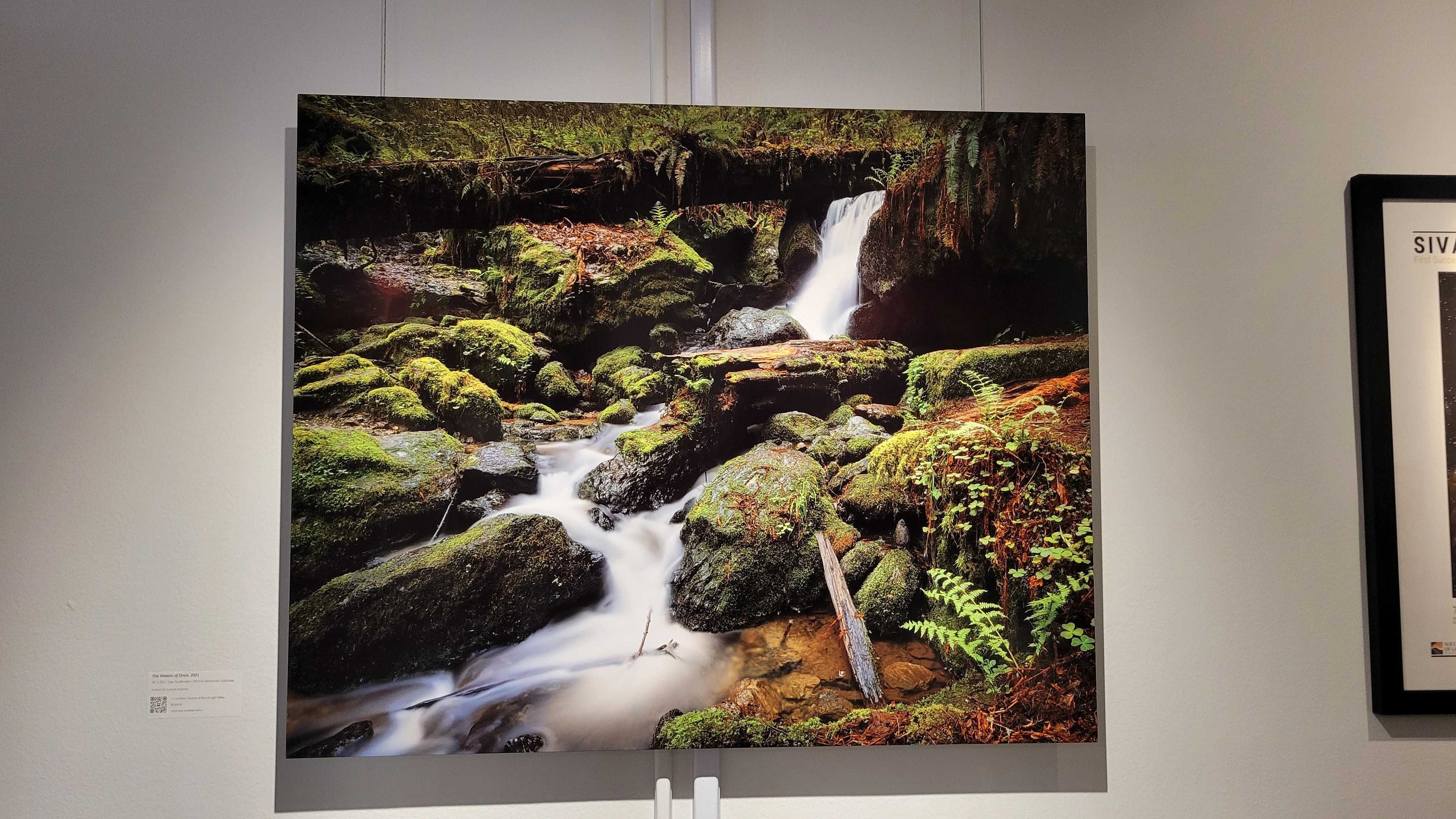 A photograph of the metal print titled "The Waters of Orick" on display in Slice of Light Gallery