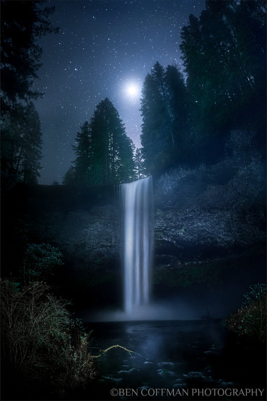 A jpg of the vertical nightscape photograph titled, "Venus in Firs" by landscape photographer Ben Coffman, featuring the planet Venus shining brightly over the 177-foot-tall South Falls on a freezing autumn morning, Oregon.