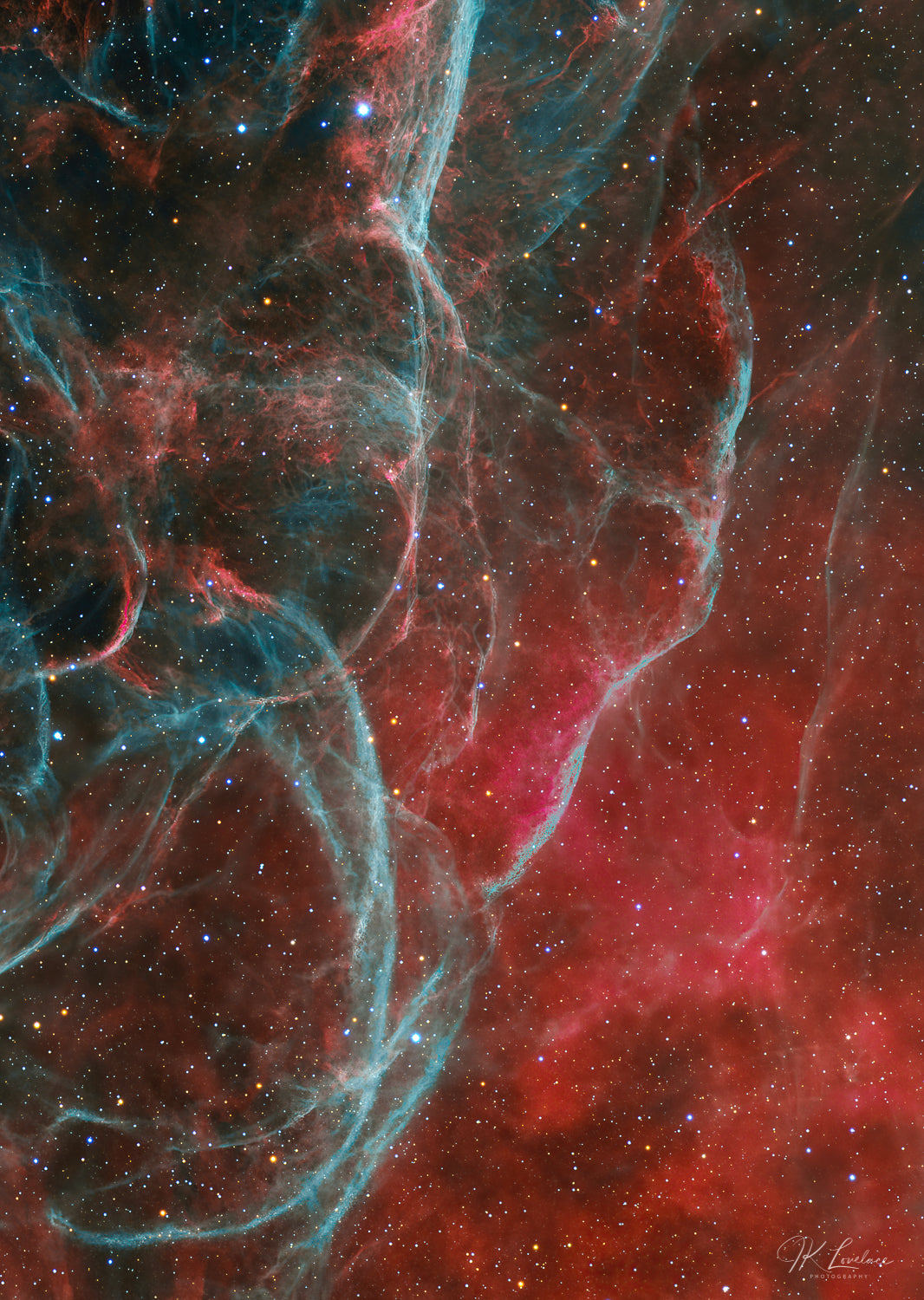 A jpg of the astrophotograph titled "Aqua Vela" shot by astrophotographer J K Lovelace featuring shockwaves of aqua colored Oxygen invading a red cloud of Hydrogen in this nebula known as the Vela Supernova Remnant.
