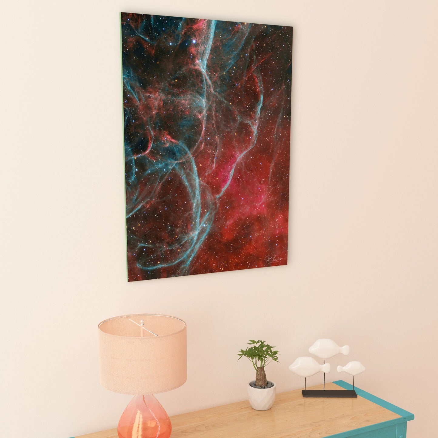 A wall art mockup featuring the metal print titled "Aqua Vela" mounted with an inset frame in a pastel pink-orange hallway with coastal contemporary wood console table with turquoise paint.