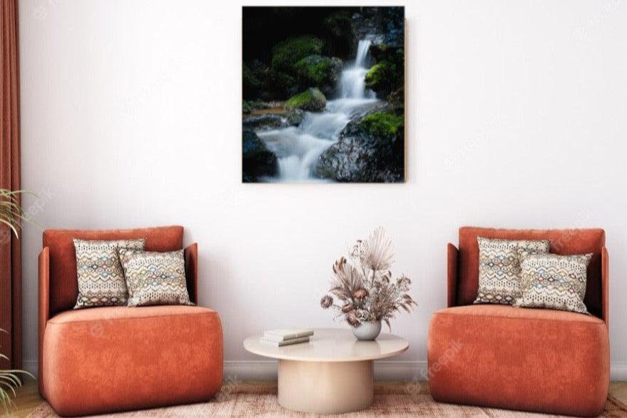 A wall art mockup of the metal print titled "Hidden Grotto" in inset frame on white wall above two salmon colored chairs.