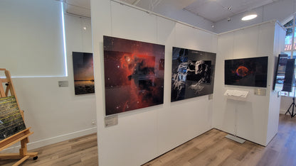 Art gallery with large space-themed artworks on white walls