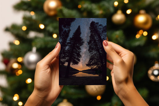 A digital mockup of a greeting card featuring the photograph titled "All is Calm" being held in someone's hands with christmas tree detail out of focus in the background.