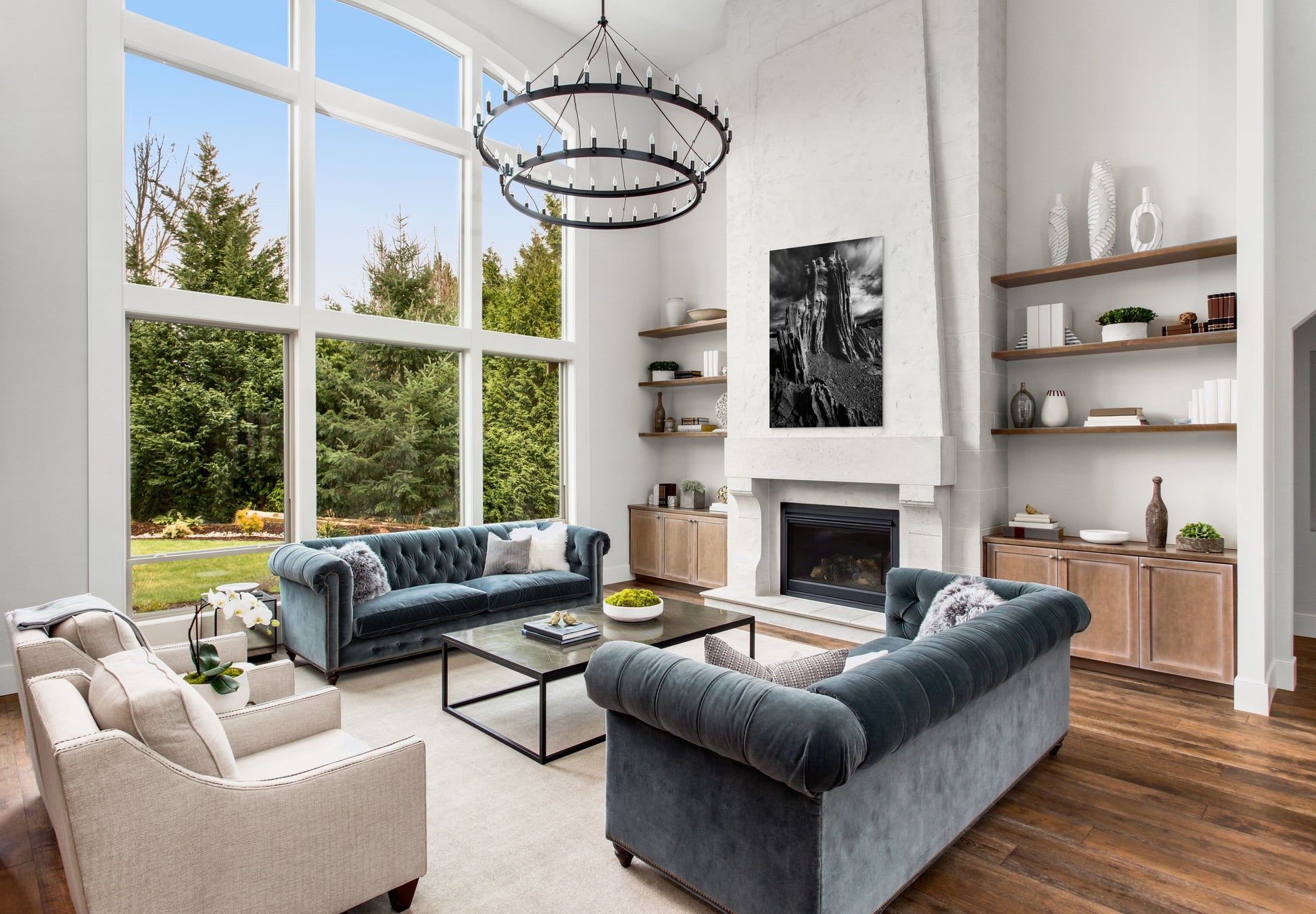 A wall art mockup featuring the photograph titled "Ancient Tower" by landscape photographer J K Lovelace as a 36 inch wide metal print with inset frame on display above a fireplace in a contemporary upscale living room.