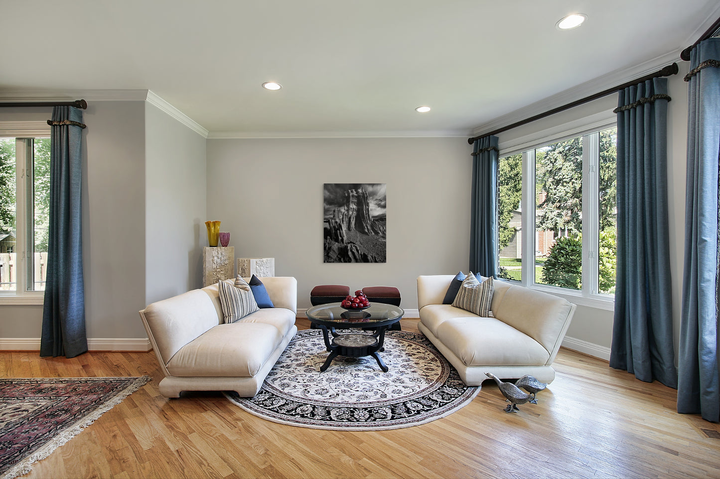 A wall art mockup featuring the black and white photograph titled "Ancient Tower" by landscape photographer J K Lovelace as a 36 inch wide metal print with inset frame on display in a classic style living room