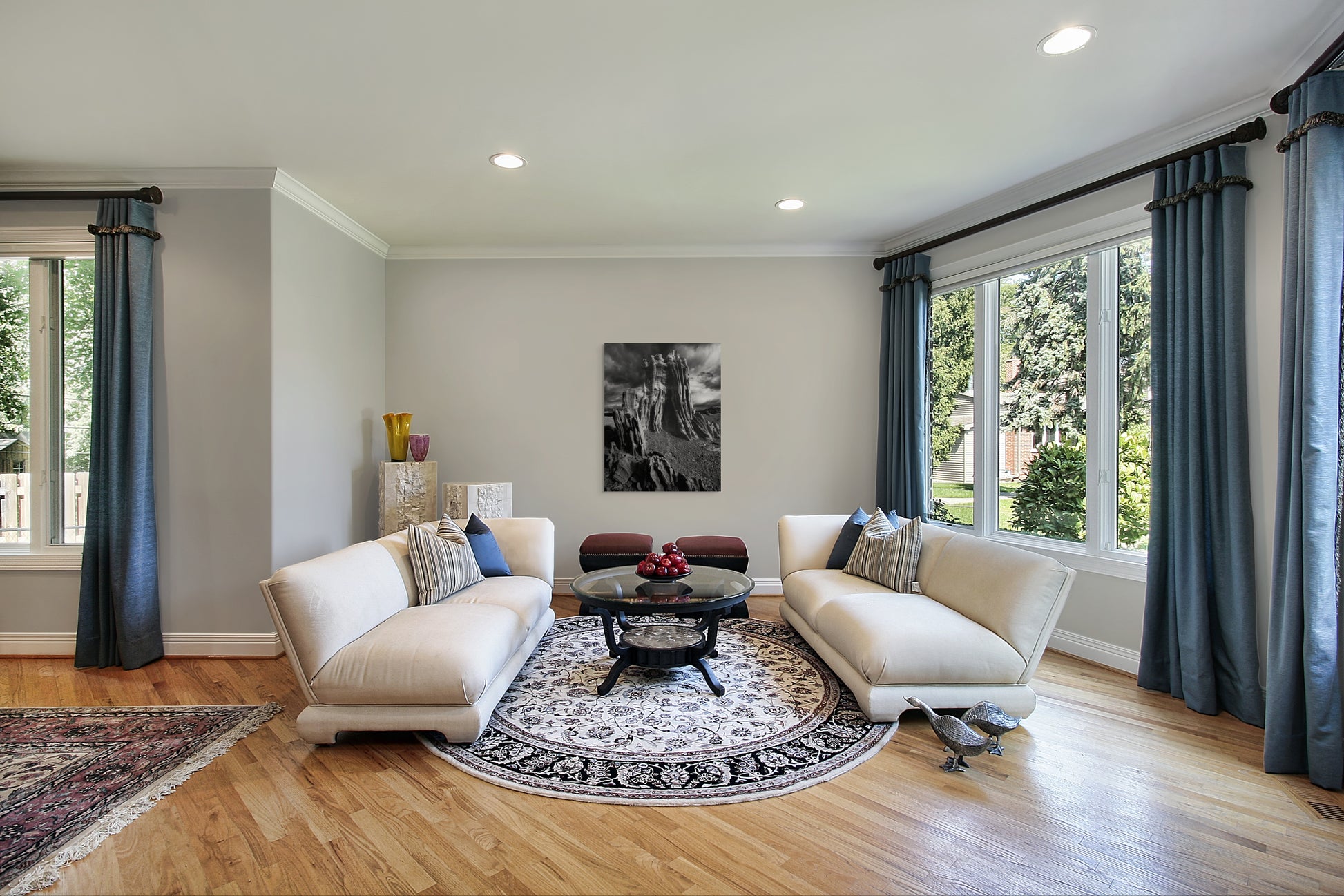 A wall art mockup featuring the black and white photograph titled "Ancient Tower" by landscape photographer J K Lovelace as a 36 inch wide metal print with inset frame on display in a classic style living room