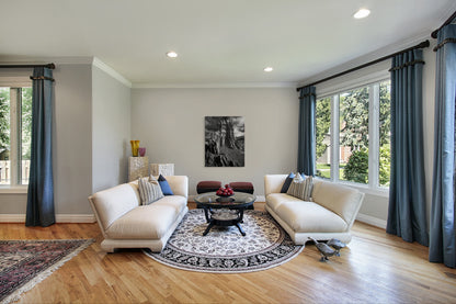 A wall art mockup featuring the black and white photograph titled "Ancient Tower" by landscape photographer J K Lovelace as a 36 inch wide metal print with inset frame on display in a classic style living room