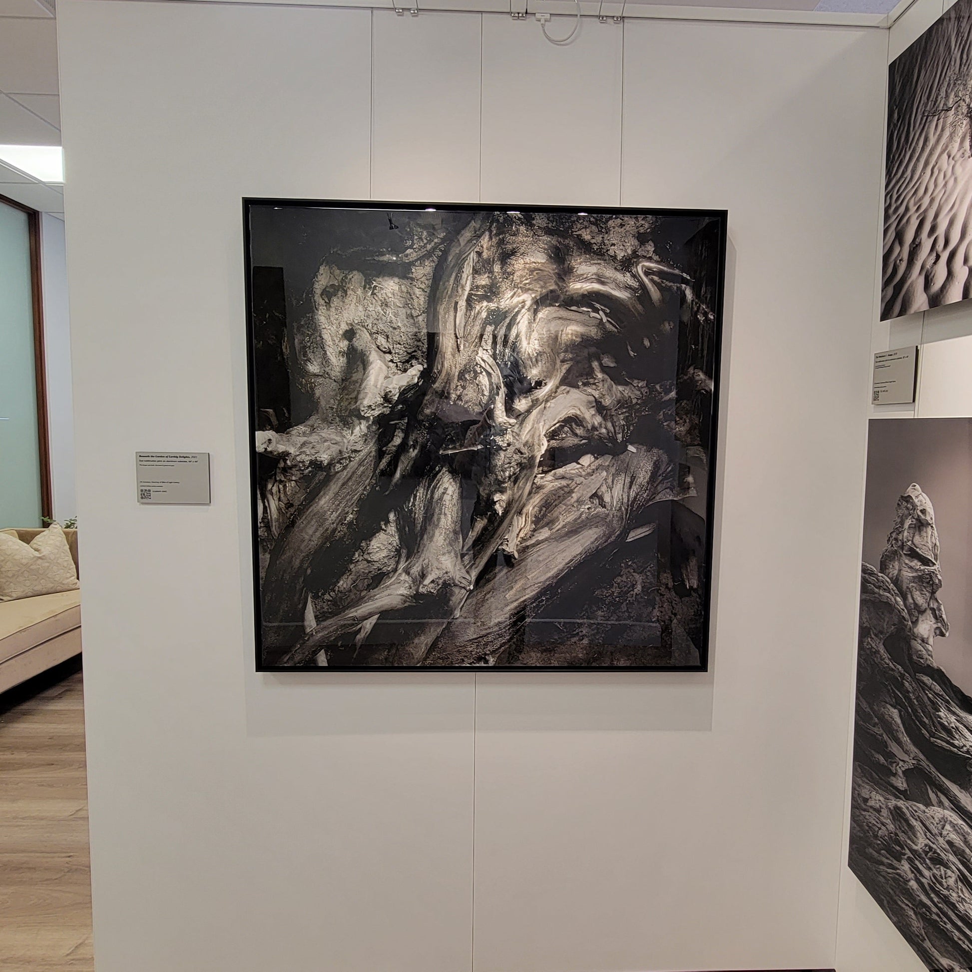 A photograph of the one-of-a-kind hand ground steel print of the photograph titled "Beneath the Garden of Earthly Delights" shot by J K Lovelace on display in the black and white cove within Slice of Light Gallery