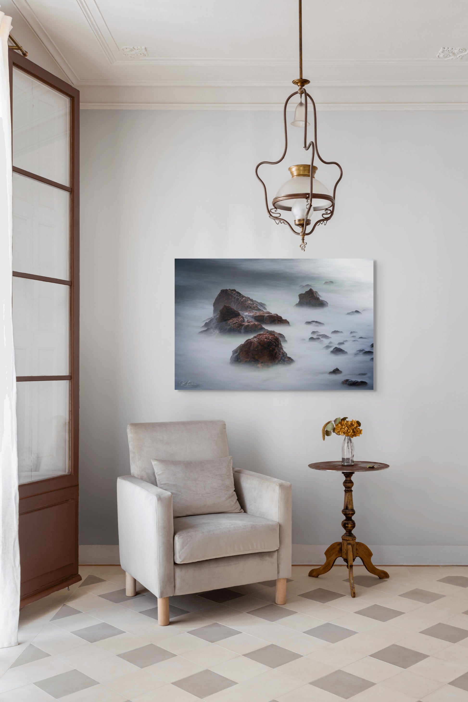 A wall art mockup featuring the photograph titled "Beyond Here Be Dragons" by landscape photographer J K Lovelace as a 44 inch wide metal print with inset frame on display in a traditional home.