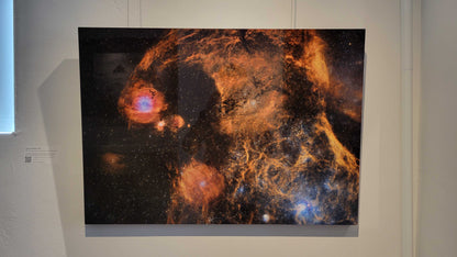 A photograph of the metal print titled "Cosmic Marbles" on display in Slice of Light Gallery