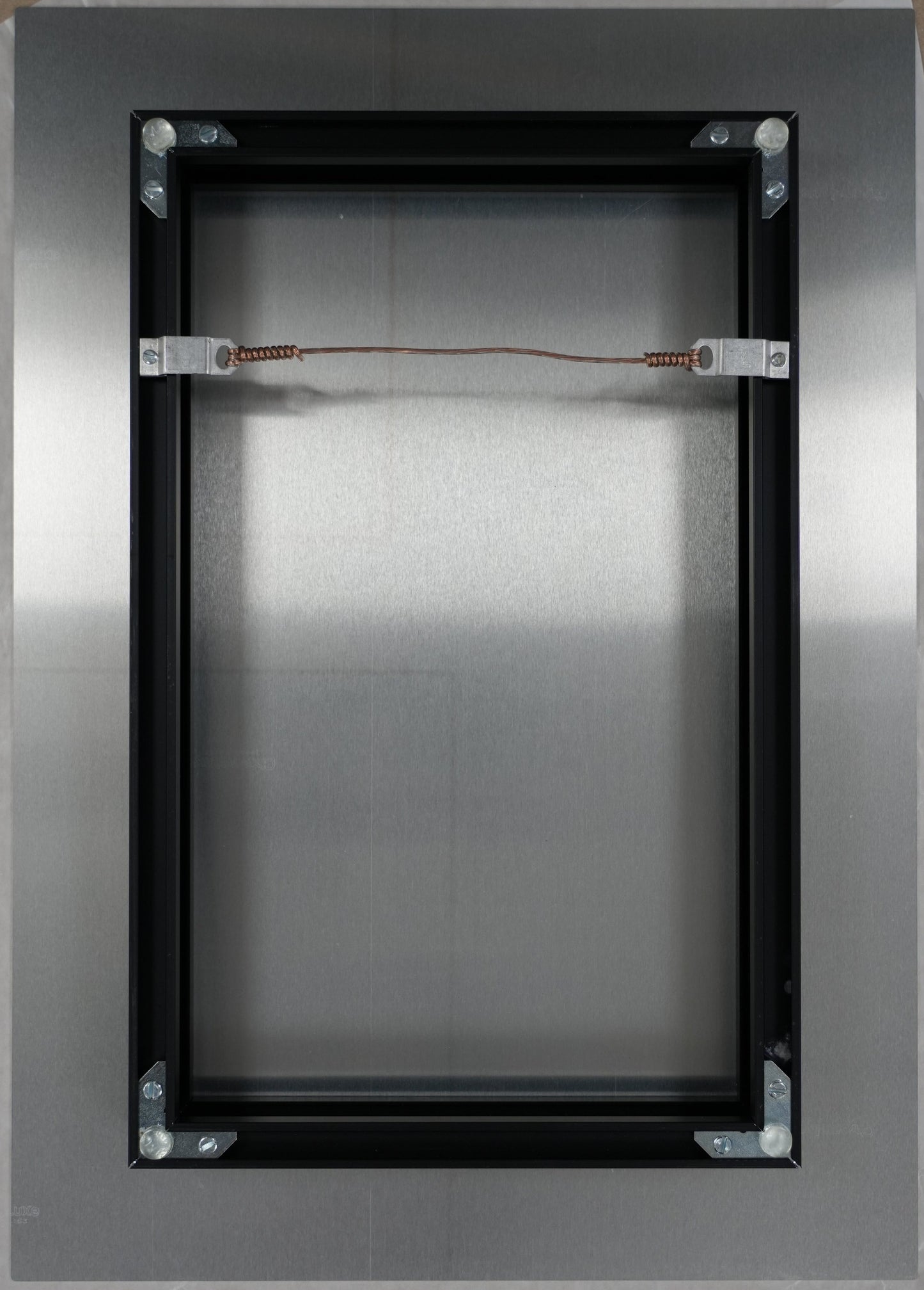 Metallic rectangular object with wires on a brown background