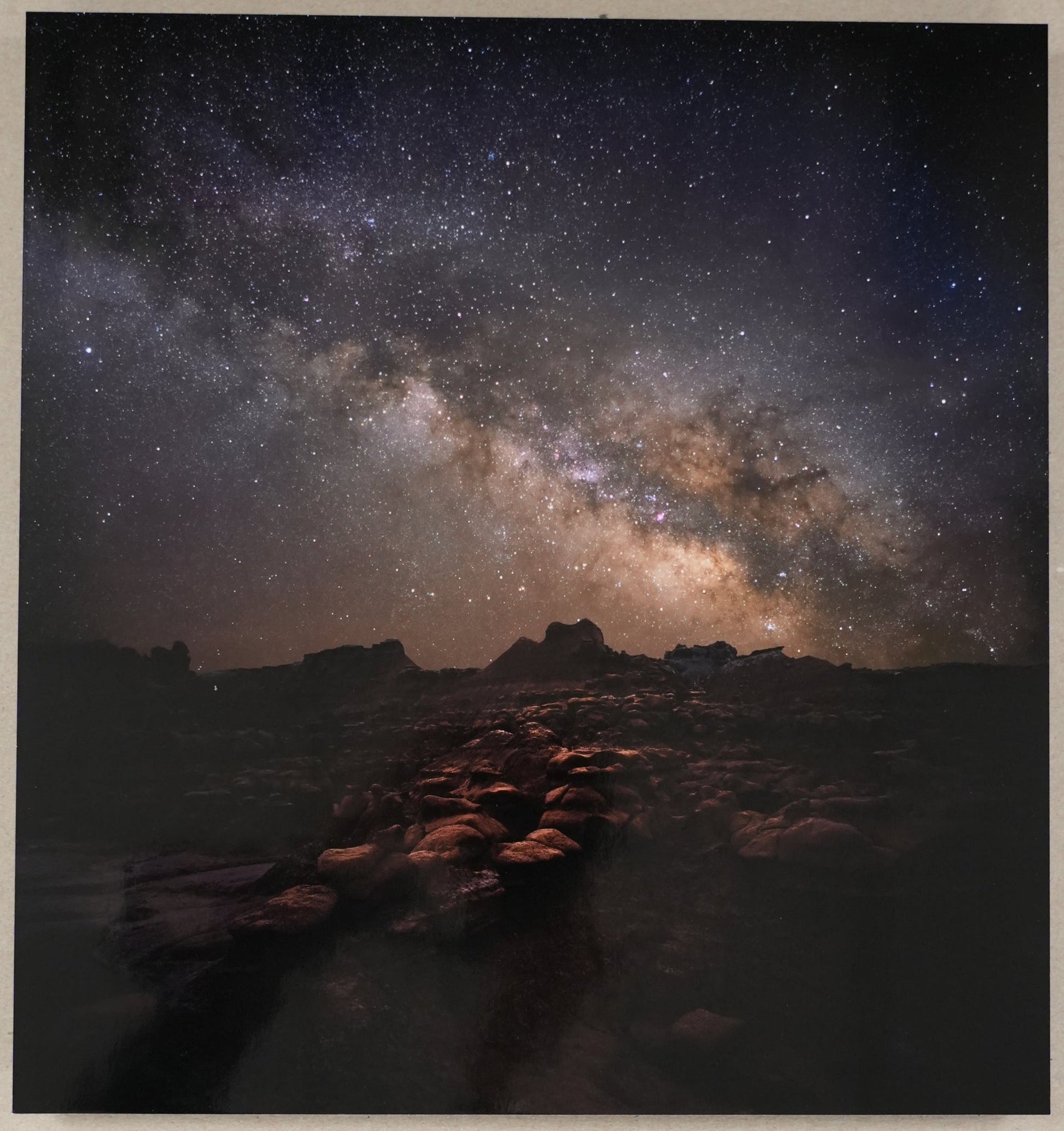 Starry night sky over a landscape with a ruler for scale on a light gray background