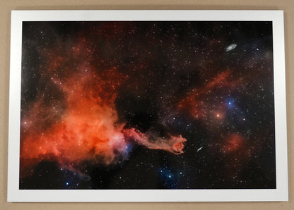 Framed space nebula print on a cardboard surface with a ruler for scale.