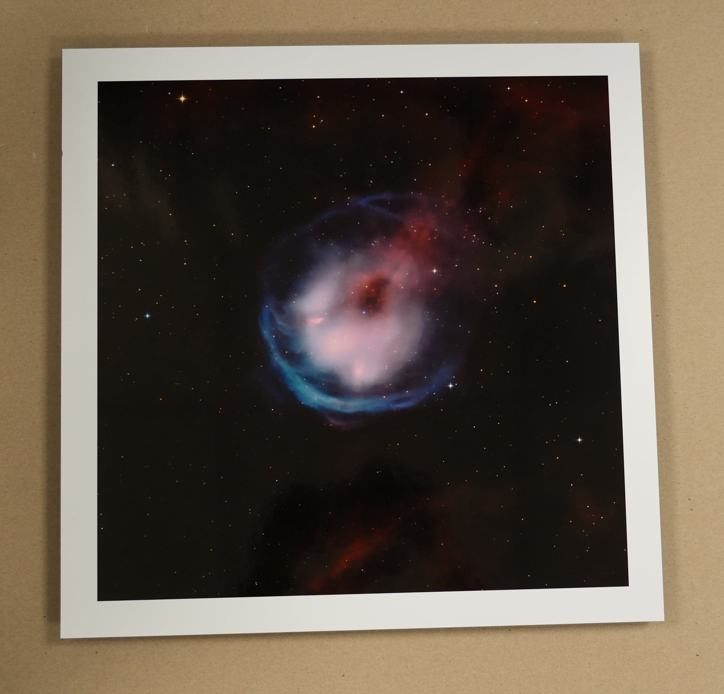 Framed space-themed print on a table with stationery items
