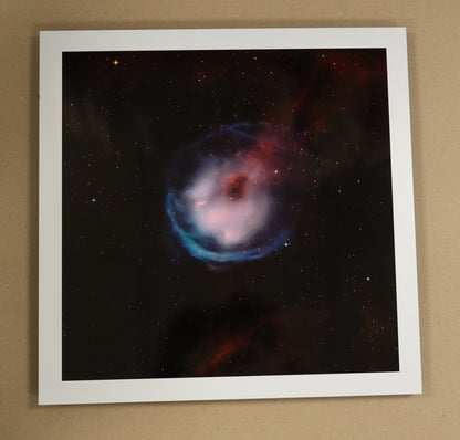 Framed space-themed print on a table with stationery items