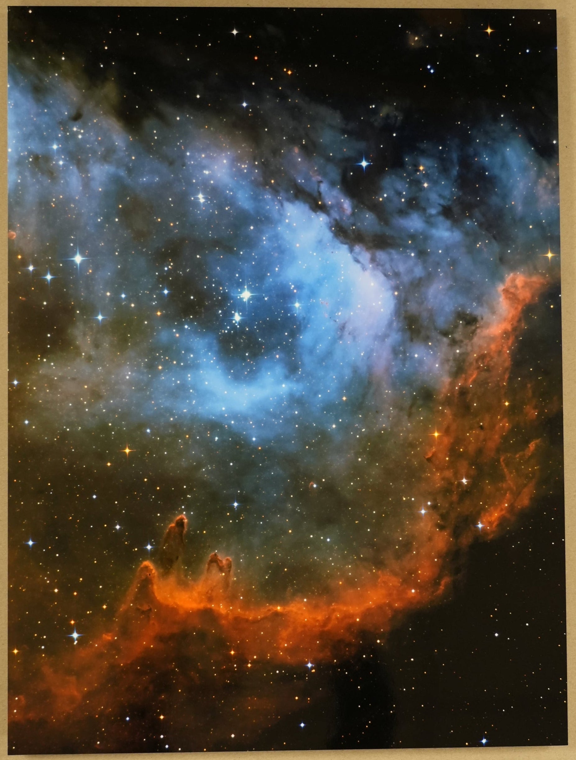 Framed photograph of a colorful nebula with a ruler at the bottom.