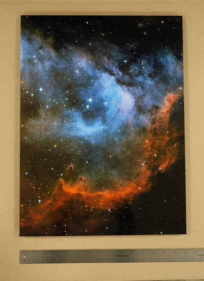 Framed photograph of a nebula with a ruler at the bottom