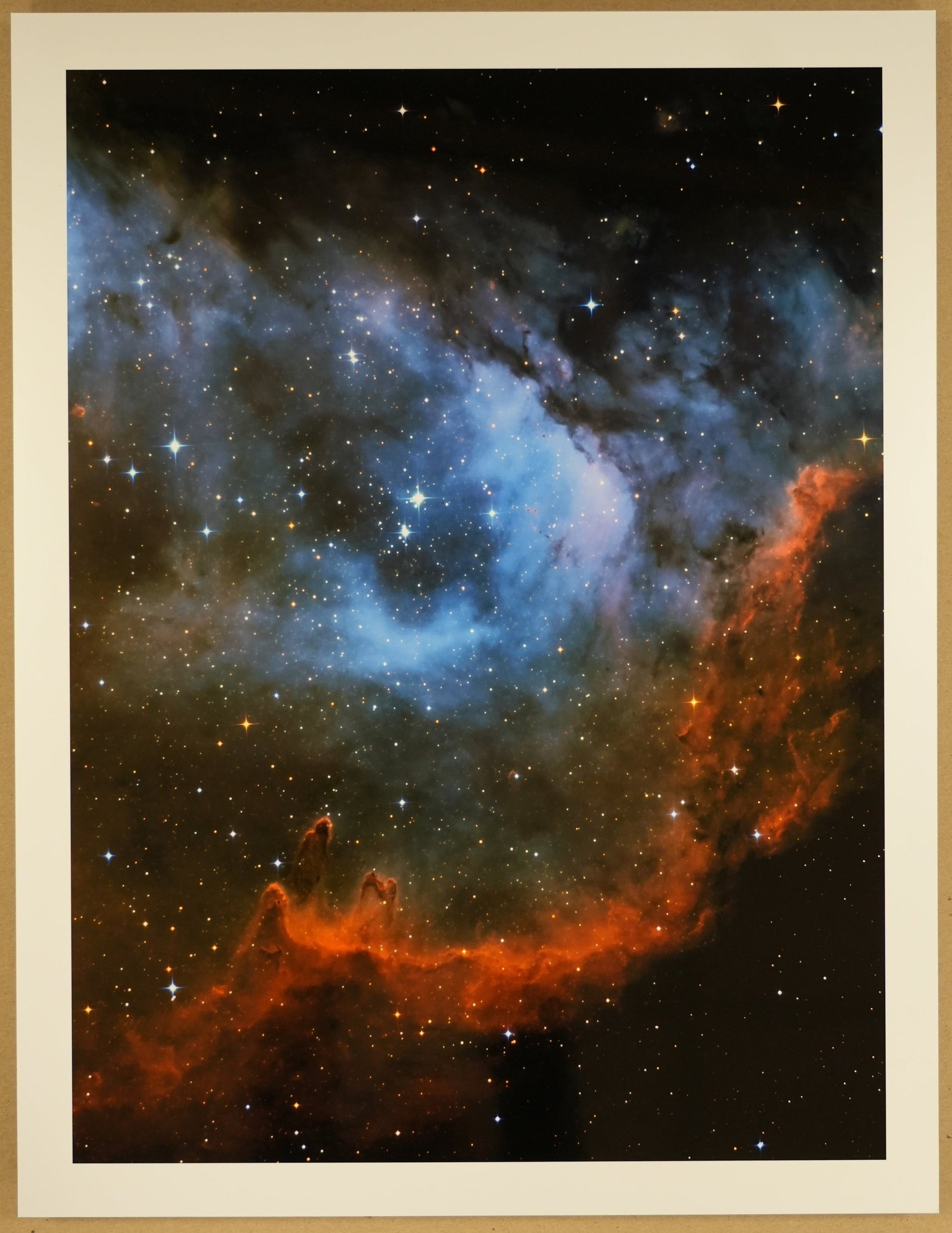 Framed photograph of a nebula with a ruler at the bottom for scale.