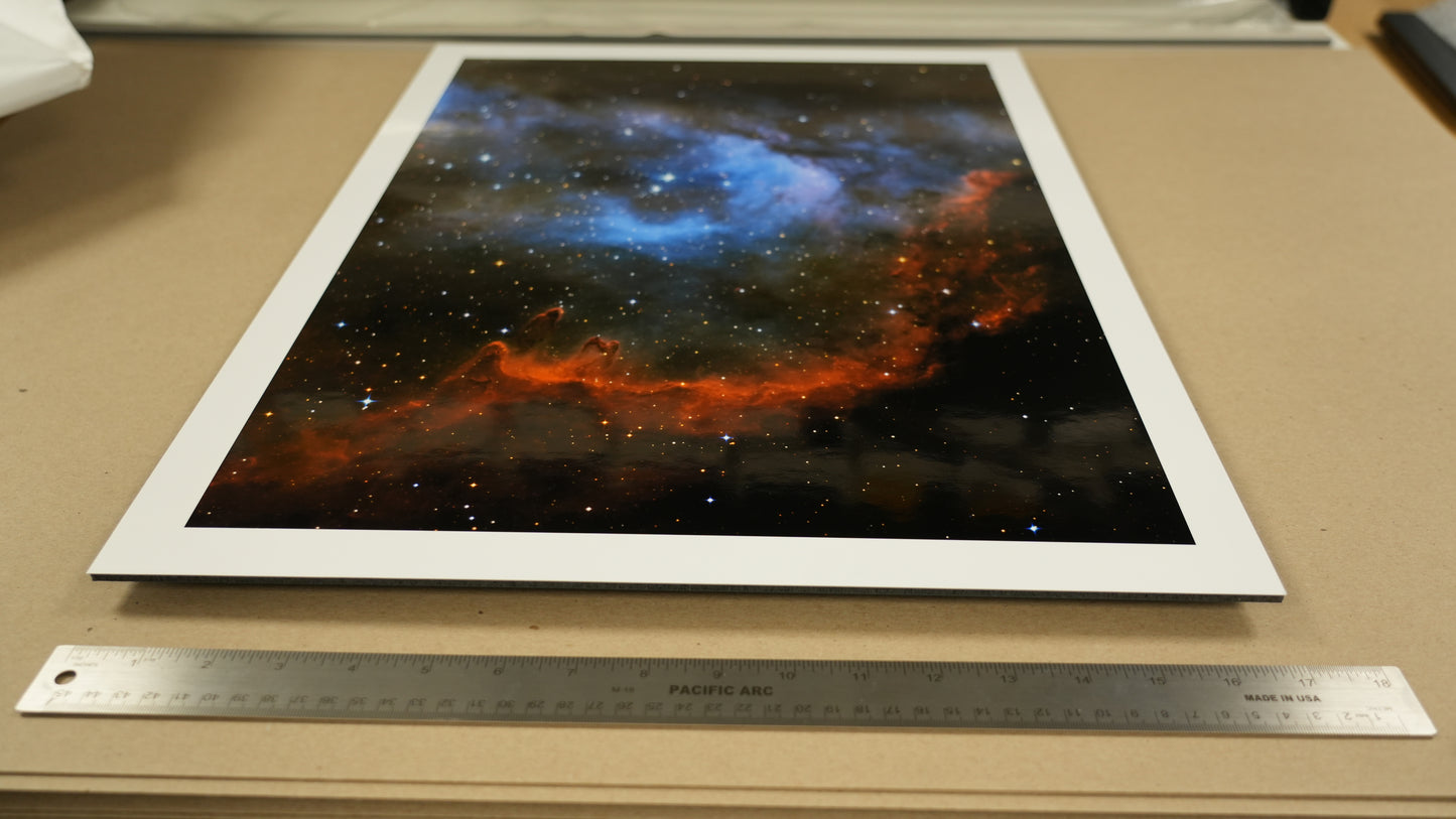 Astrophotographic print of a nebula on a table with a ruler for scale.