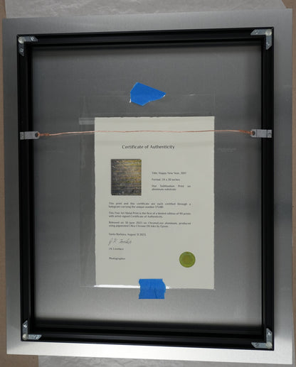 Framed document with a blue sticker on a cardboard surface