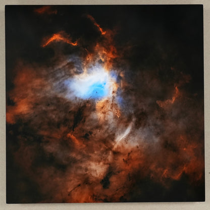 Starry night sky with a nebula and a ruler for scale on a beige wall.