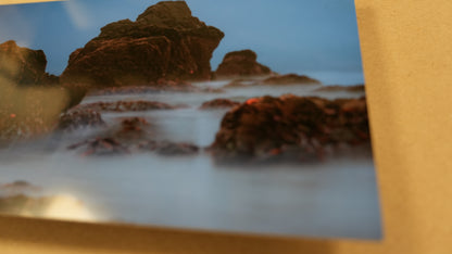 Rocks with water splashing around them on a beach