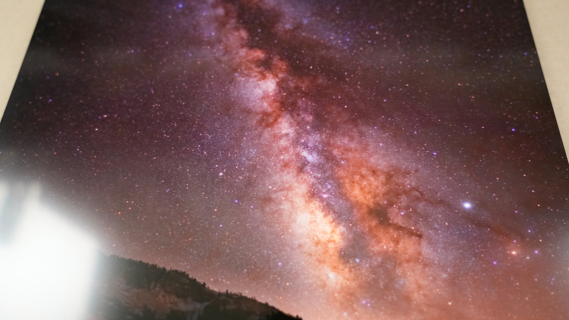 Starry night sky with the Milky Way galaxy over a mountainous landscape.