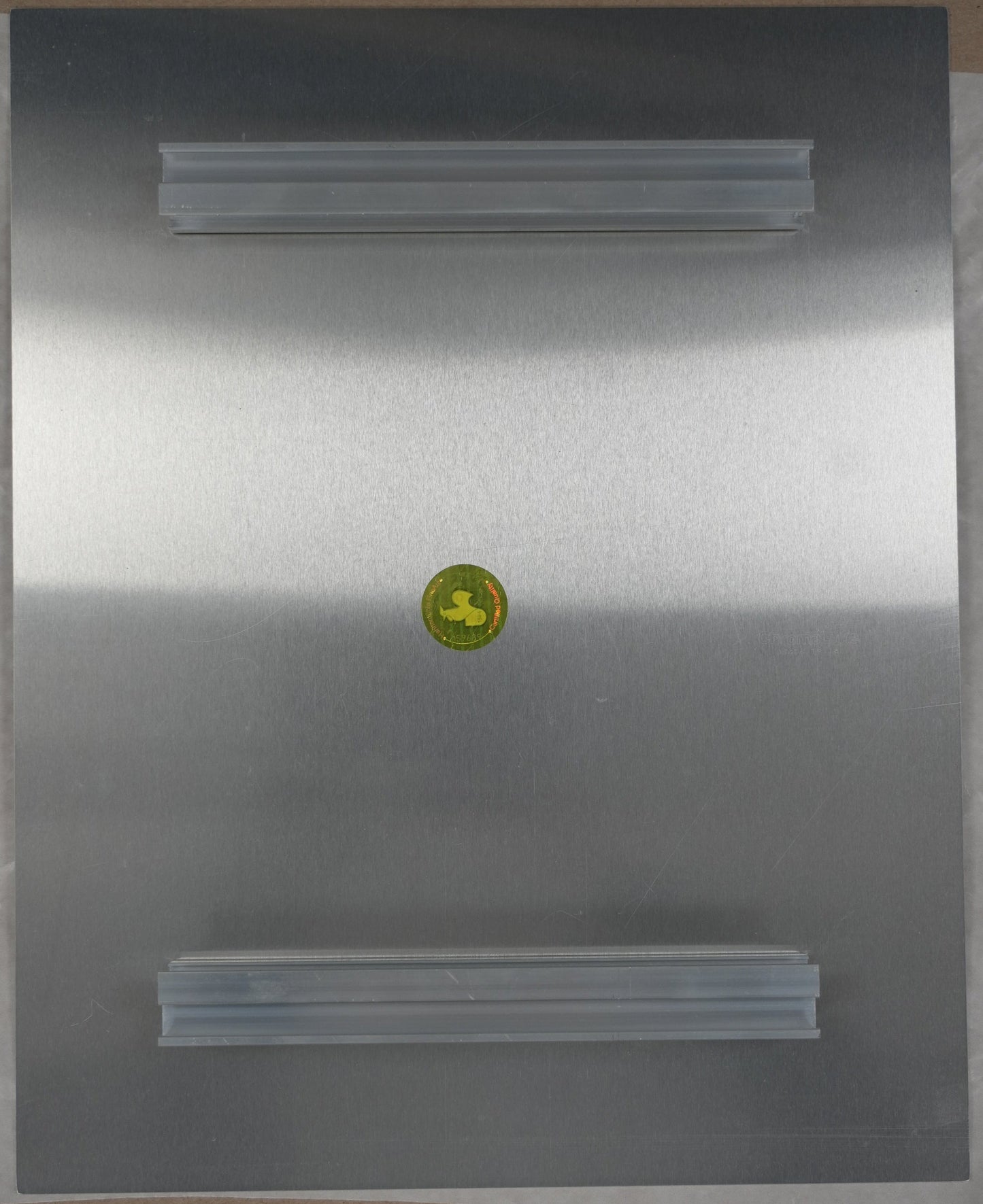 Metallic surface with a yellow circular label on a cardboard background