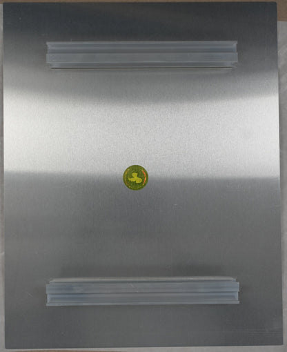 Metallic surface with a yellow circular label on a cardboard background