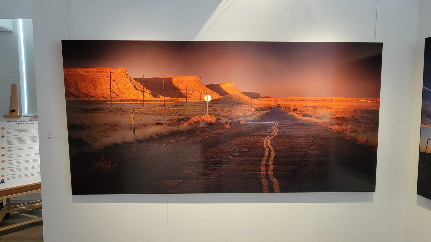 A photograph of the 96 inch wide metal print titled "Heading Home" on display in Slice of Light Gallery.