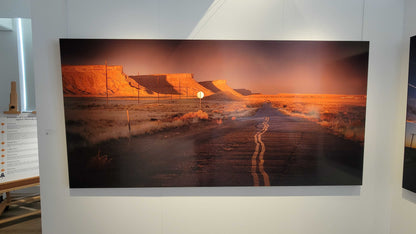 A photograph of the 96 inch wide metal print titled "Heading Home" on display in Slice of Light Gallery.