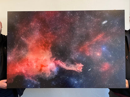 Person holding a photograph of a colorful nebula