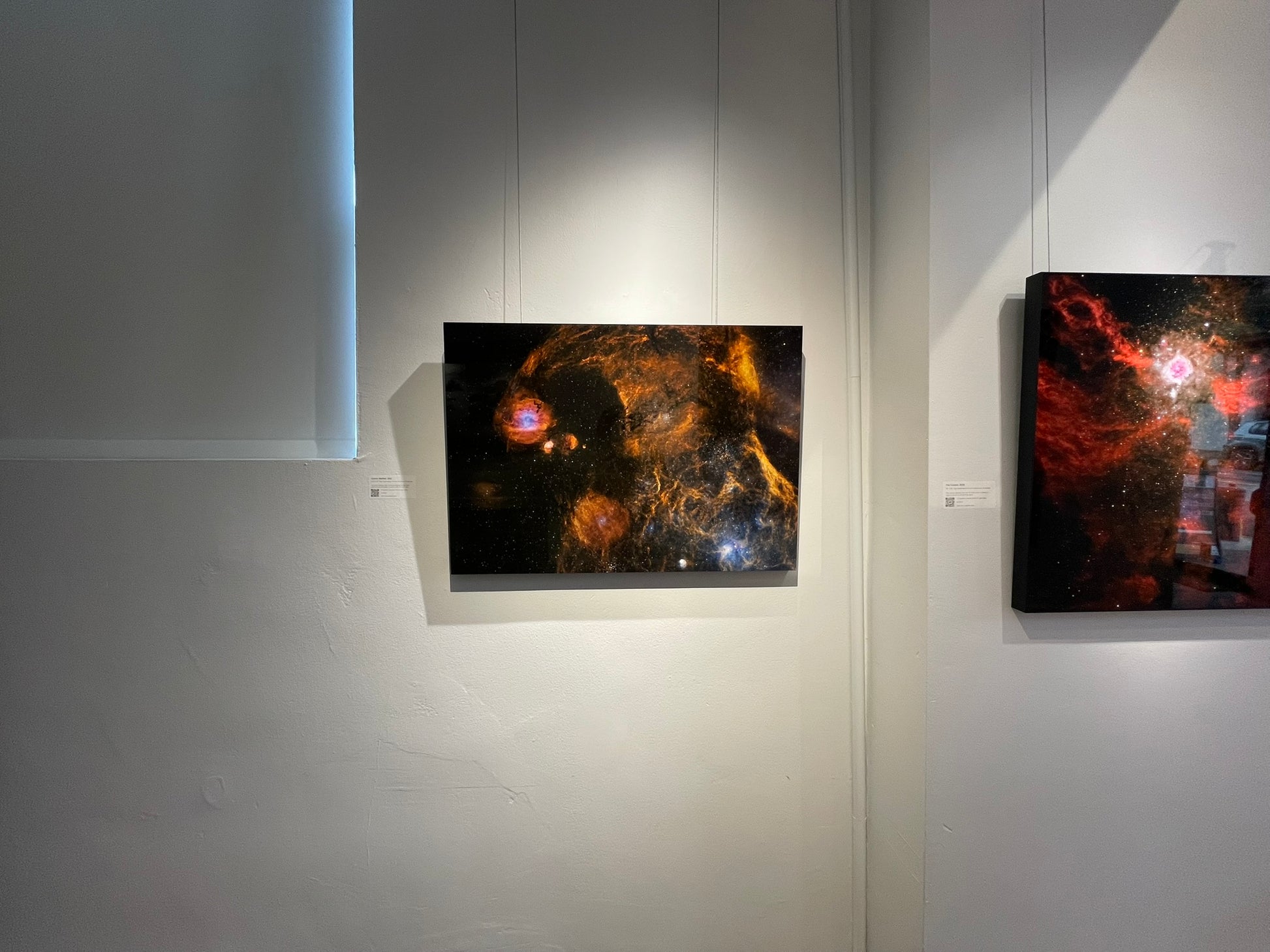 Two pieces of space-themed artwork on a white wall