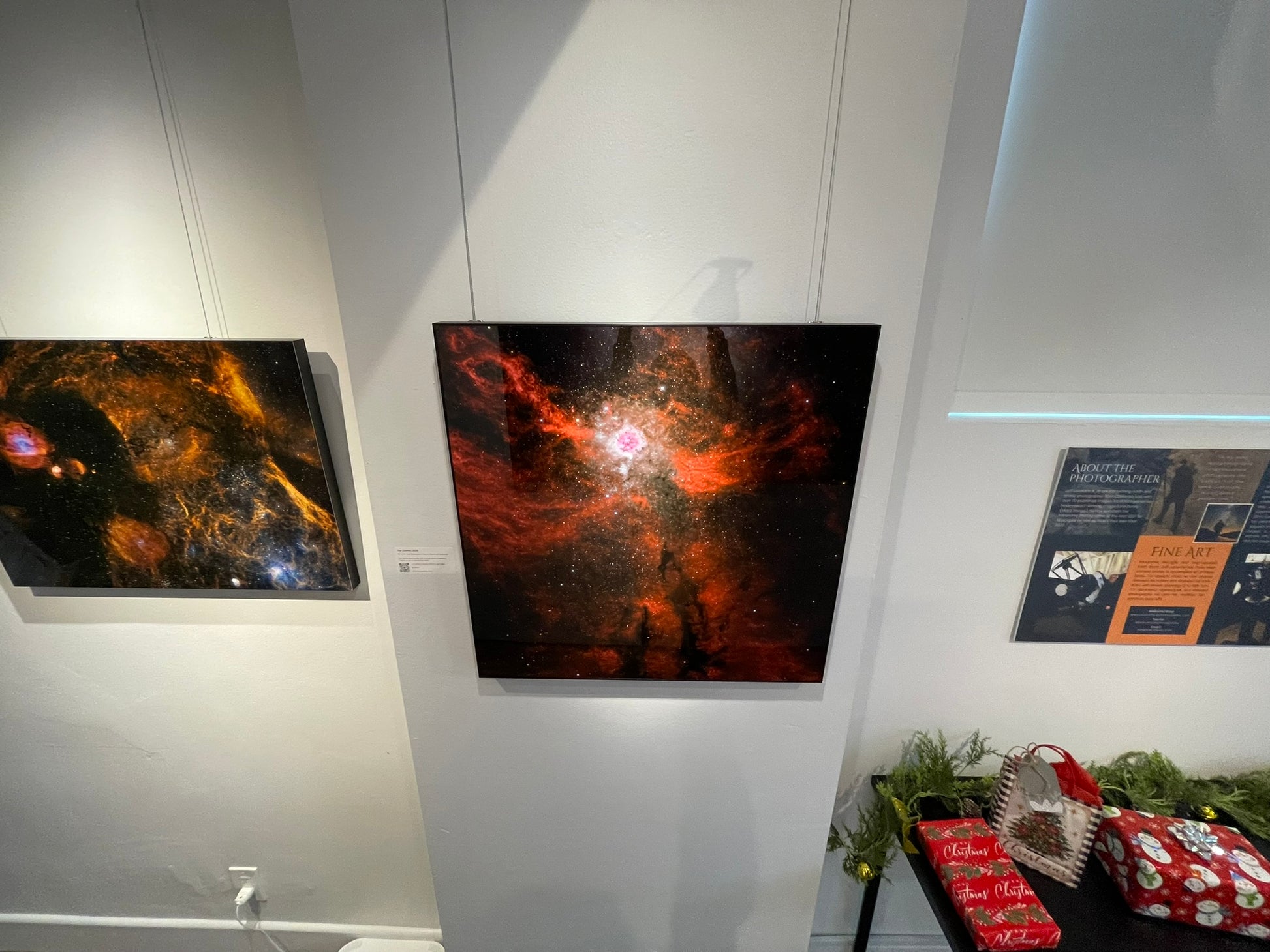 Two large space-themed artworks on a wall with a smaller poster below.