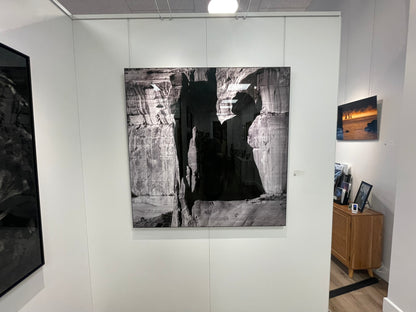 Art gallery with large black and white landscape painting on a white wall